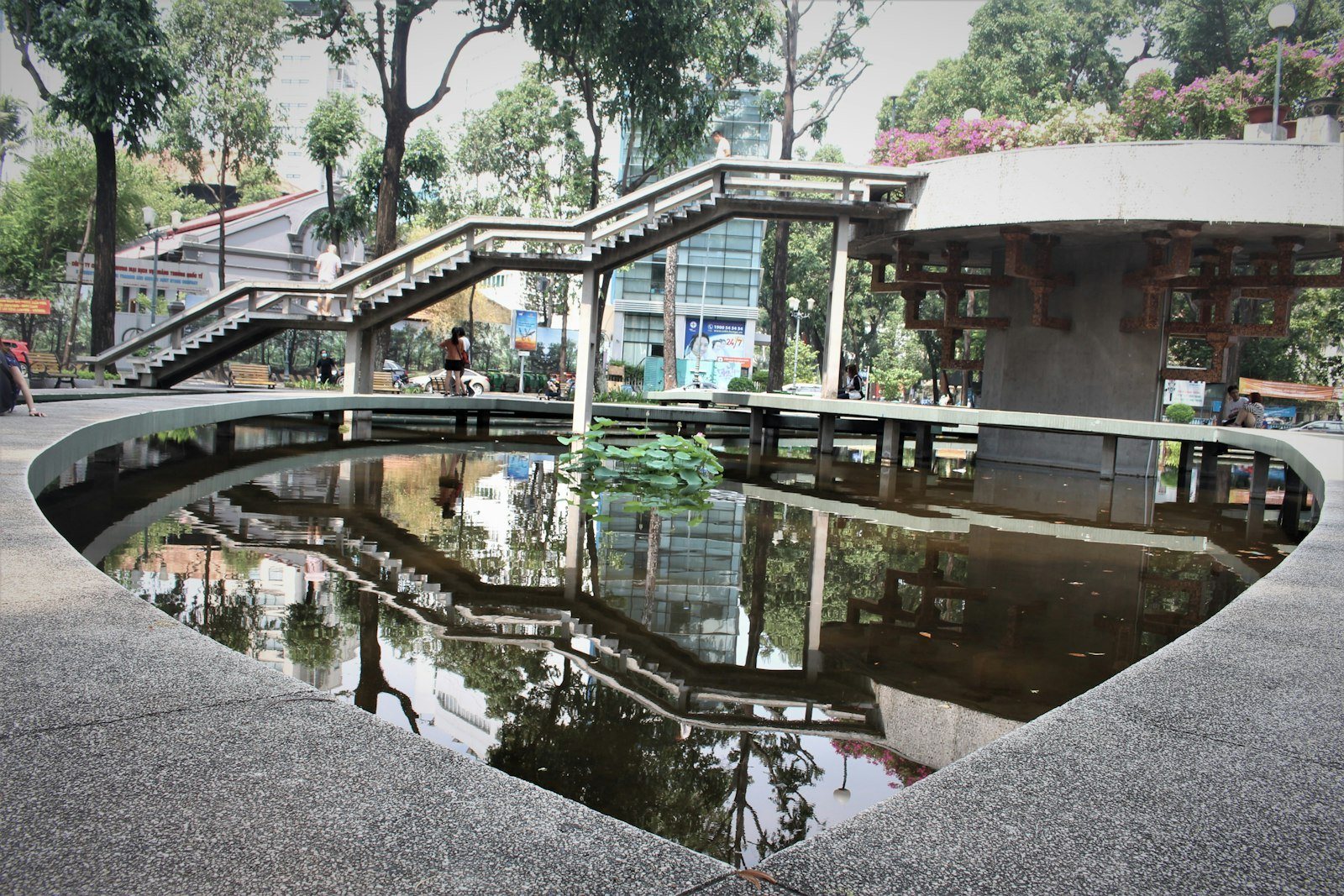 Công viên trong thành phố với hàng cây lớn và người đi dạo