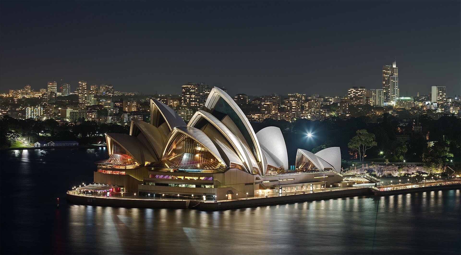 Nhà hát Opera Sydney rực sáng bên cảng lúc đêm với dãy mái vỏ sò trắng