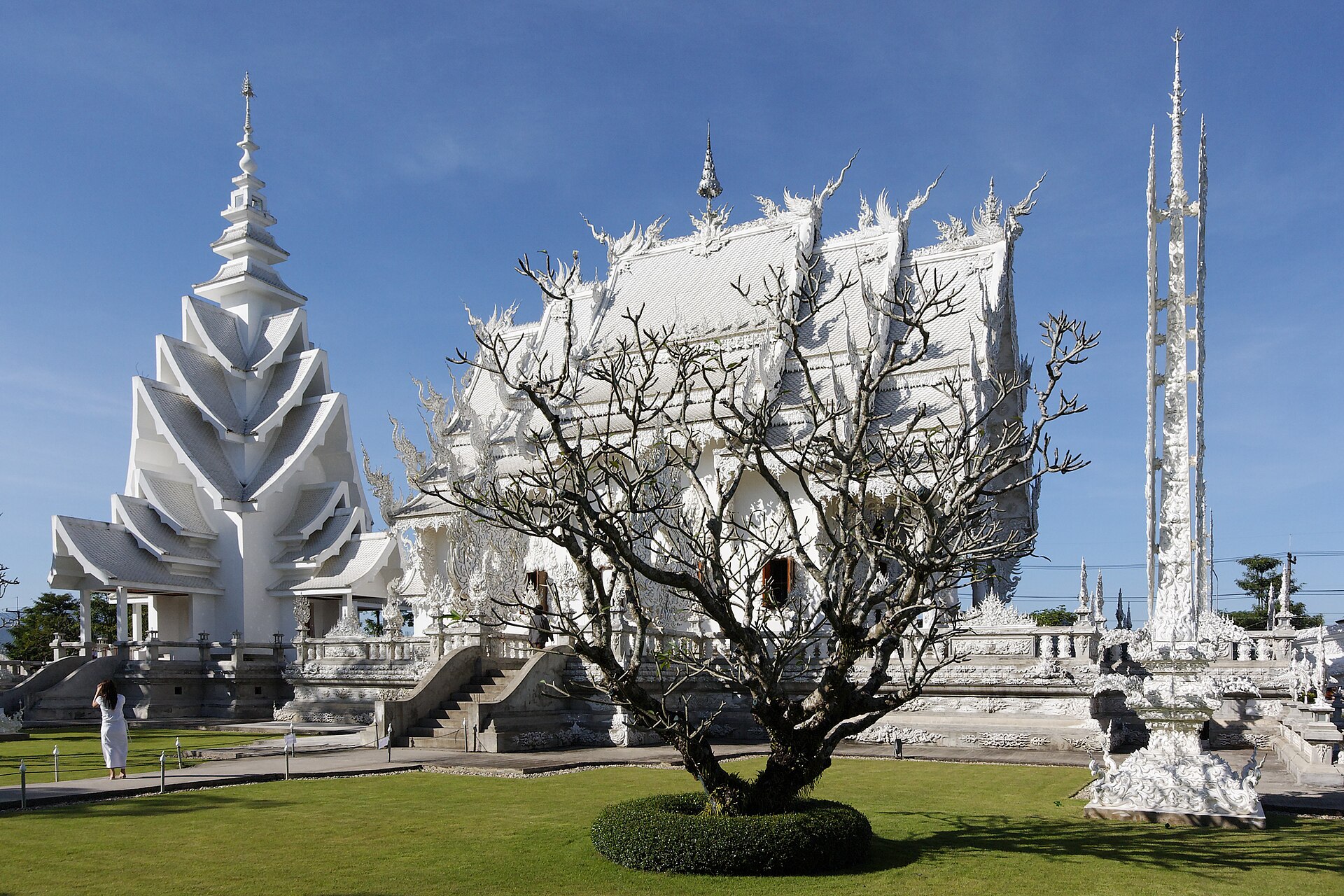 Chùa Trắng Wat Rong Khun với các mái đầu đao trắng chạm trổ cầu kỳ dưới trời xanh