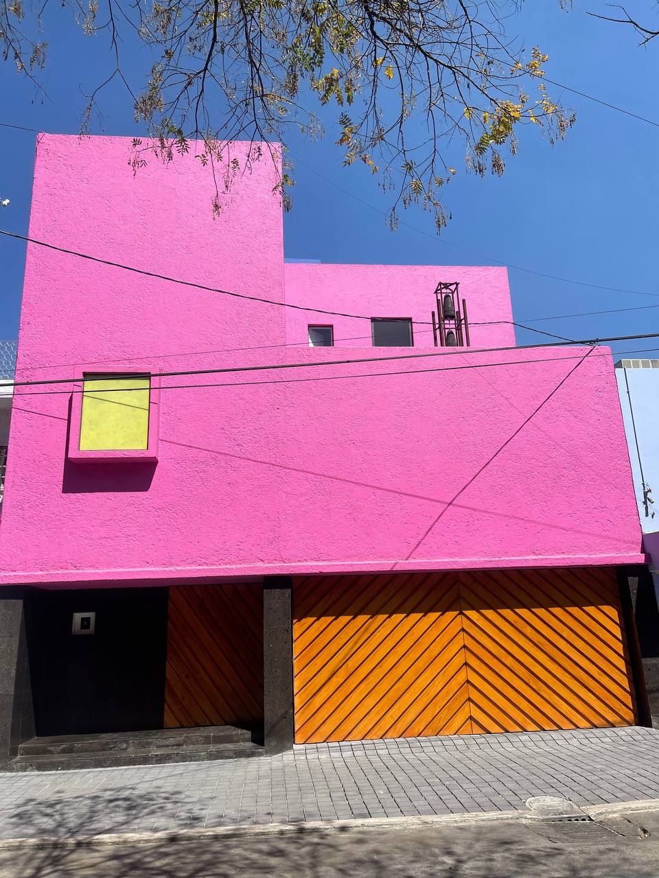 Mặt tiền hồng rực của Casa Gilardi do Luis Barragán thiết kế với cửa gỗ vàng cam