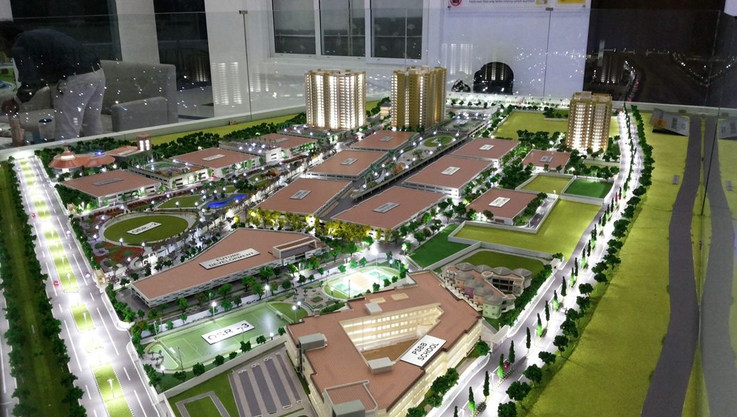 Mô hình maquette dựng bằng bìa, gỗ balsa hoặc nhựa mica thu nhỏ toàn bộ khu đất theo một tỷ lệ cố định, thể hiện khối công trình, mảng cây xanh, mặt nước và mạng lưới đường nội bộ cùng lúc trên một mặ...