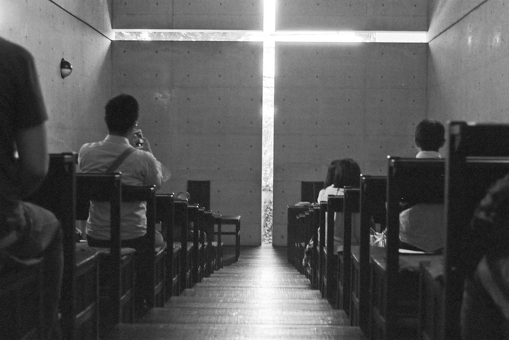 Nội thất Church of the Light với khe sáng hình thánh giá và hàng ghế gỗ