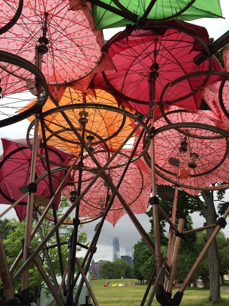 Vành xe đạp, ô hỏng và bìa carton — Tán ô hồng cam của Organic Growth Pavilion nhìn