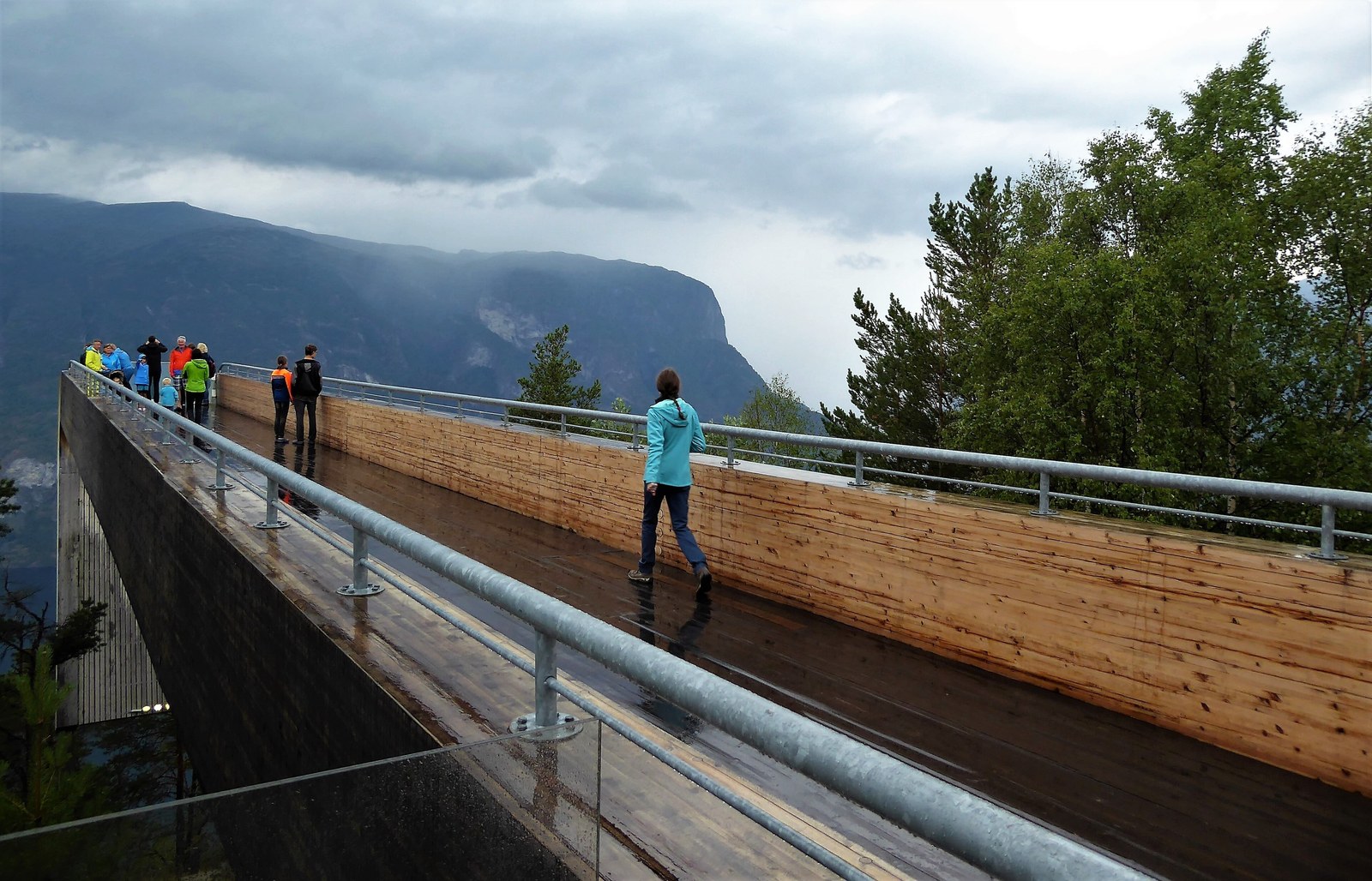 Aurland Lookout — Khách đi dọc sàn ván Stegastein ướt mưa