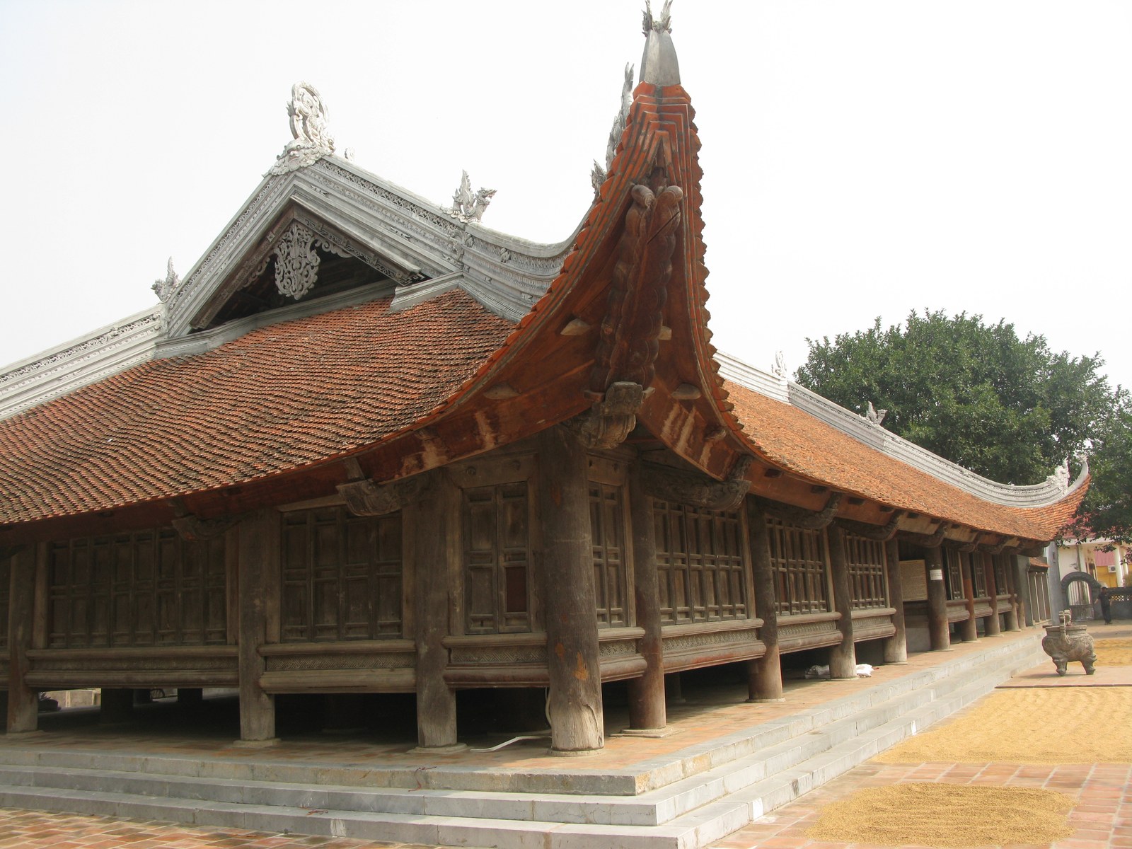 Toàn cảnh đình nhìn từ sân trước, mái ngói cong nhiều lớp, cổng và trụ biểu phía trước dẫn vào tòa chính