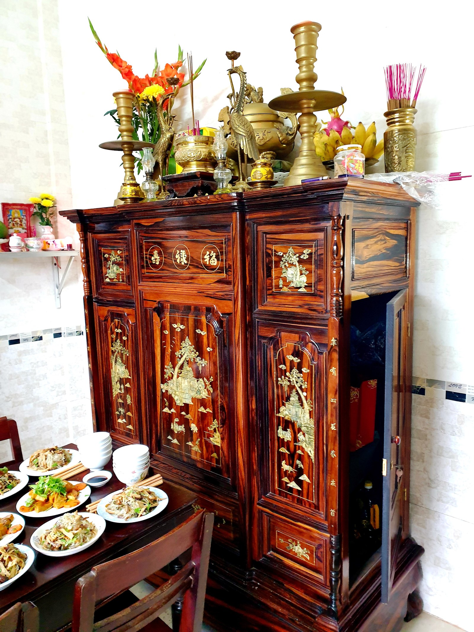 Tủ thờ gỗ sơn son, bàn cỗ cúng đầu năm phía dưới