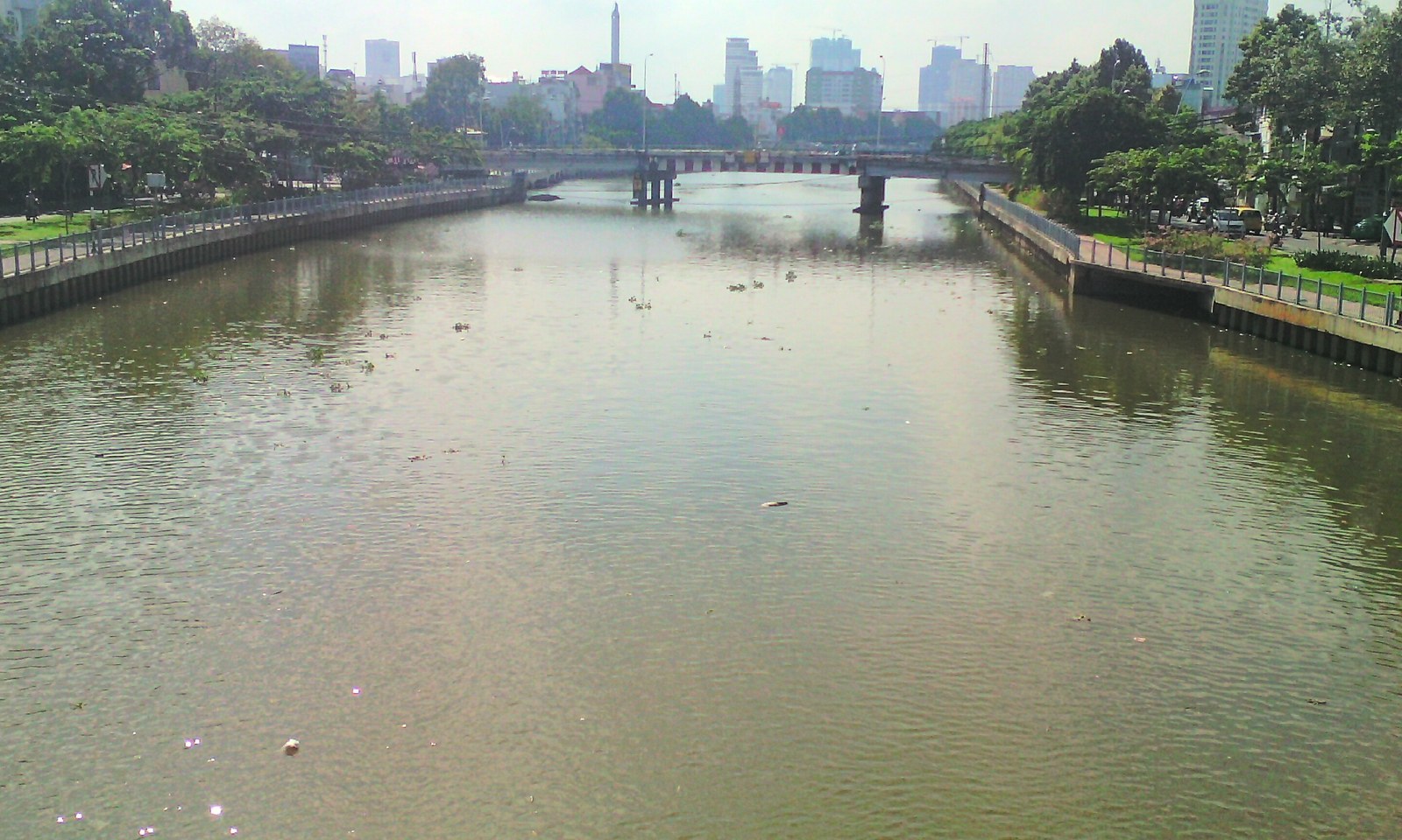 Kênh Nhiêu Lộc – Thị Nghè, TP.HCM — lòng kênh kè bê tông thẳng nhìn từ cầu Bông, cầu và skyline trung tâm phía xa