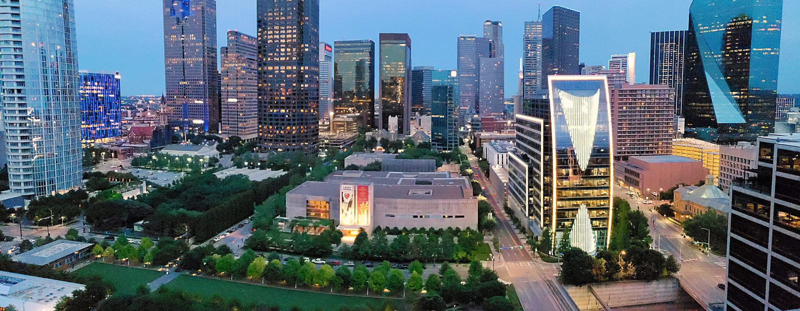 Klyde Warren Park — Ảnh toàn cảnh công viên về đêm với skyline