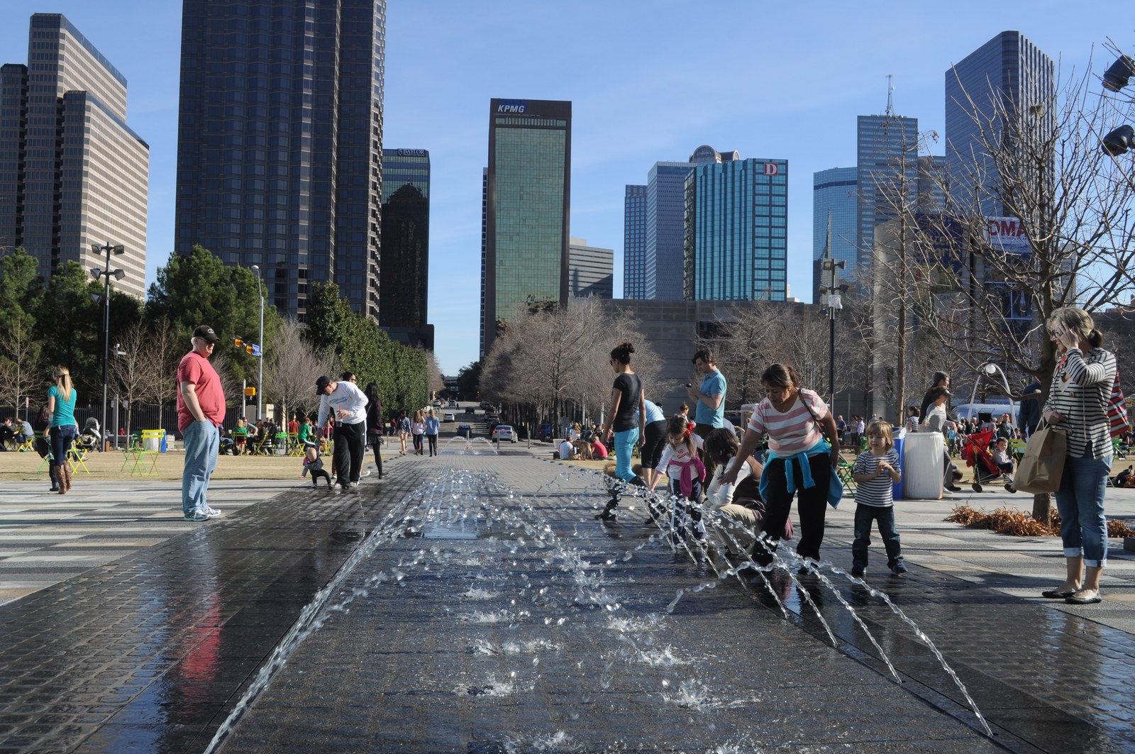 KLYDE WARREN PARK — Đài phun nước dạng tia (splash pad) với nền