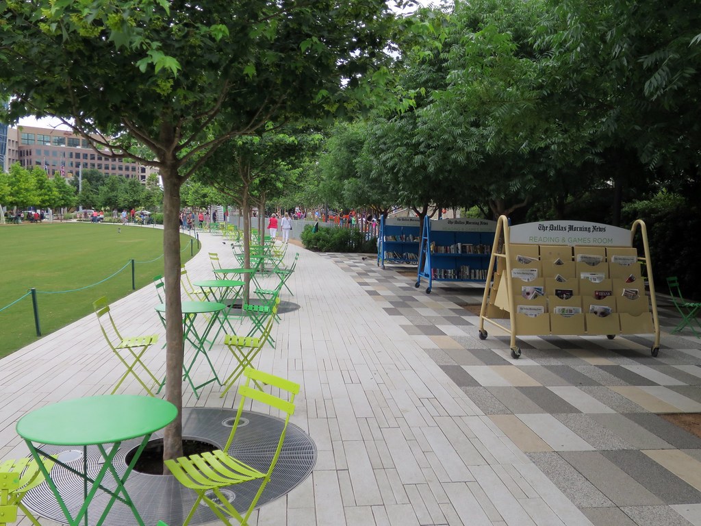 KLYDE WARREN PARK — Lối lát gạch với bàn ghế xếp xanh lá