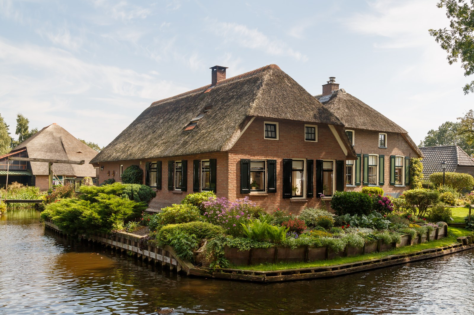 Một tuyến kênh Giethoorn với nhà mái tranh và cây xanh hai bên bờ