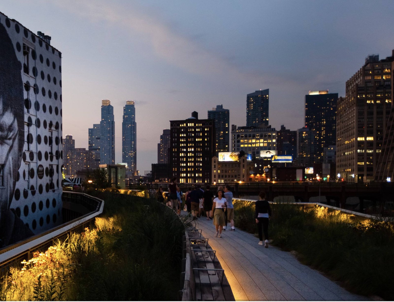 High Line lúc hoàng hôn với đèn vàng dọc lối và nền trời tím