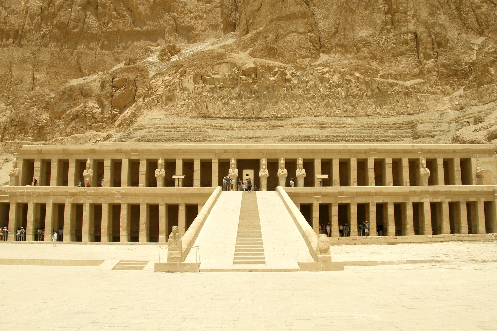 Đền tang lễ Hatshepsut ở Deir el-Bahari nhìn từ xa, các dãy cột đá vôi xếp thành nhiều tầng sân bậc áp sát vách núi đá, một lối bậc thang trung tâm dẫn lên