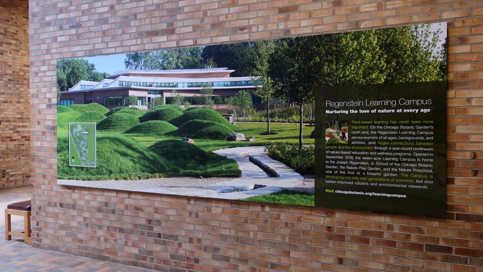 Bảng thông tin lớn tại Visitor Center giới thiệu Regenstein Learning Campus, kèm ảnh gò đồi cỏ và bản đồ khu vực