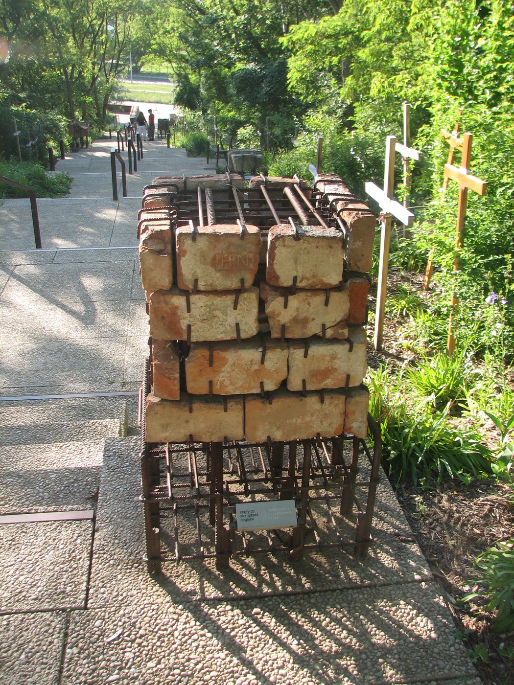 Chồng gạch cũ đặt cạnh lối đi trong công viên trên Warsaw Uprising Mound, cây cối mọc quanh