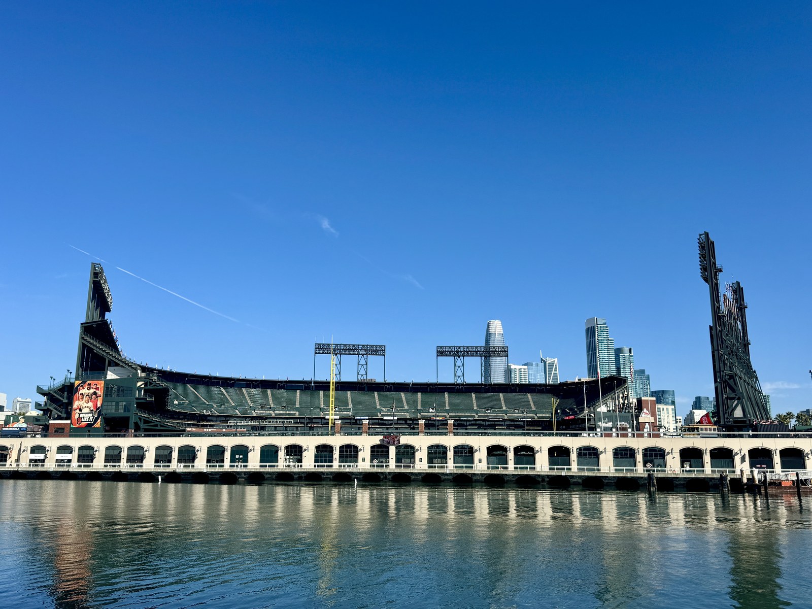 China Basin Park nhìn từ mặt nước, phía sau là sân vận động Oracle Park và các toà nhà cao tầng San Francisco