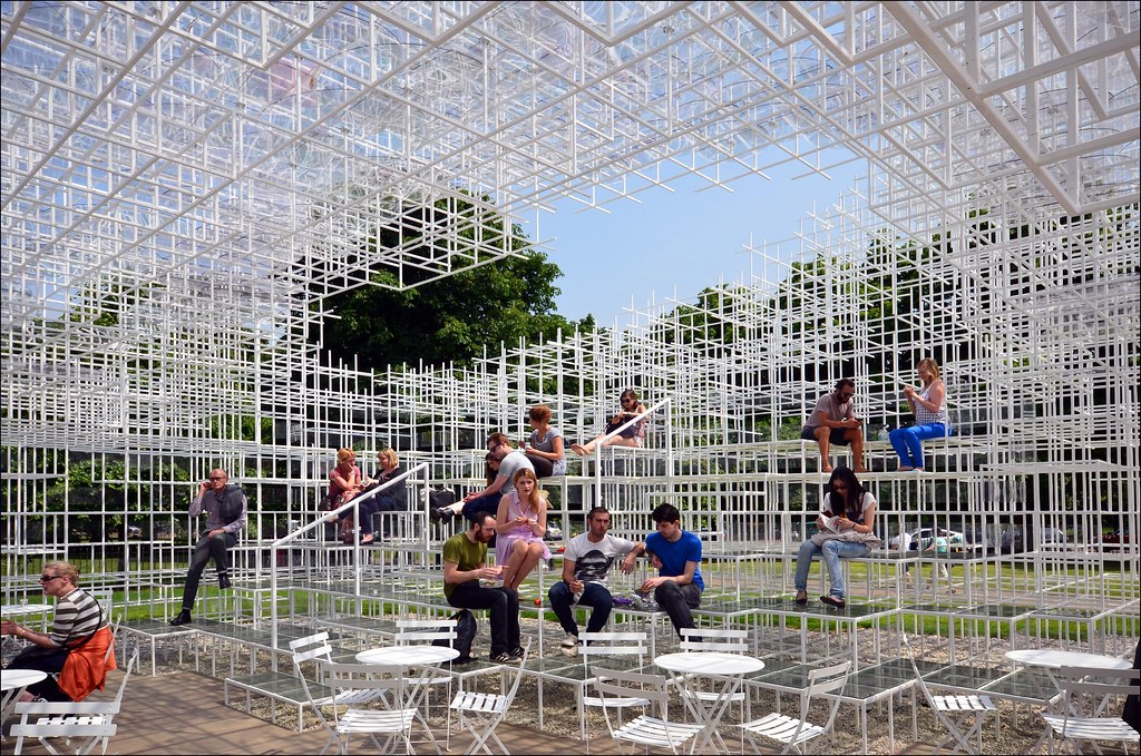 Trẻ em chơi đùa dưới mái lưới thép có các đĩa polycarbonate trong suốt xen giữa, ánh nắng lọt qua